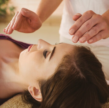 Young woman having a reiki treatment in therapy room
